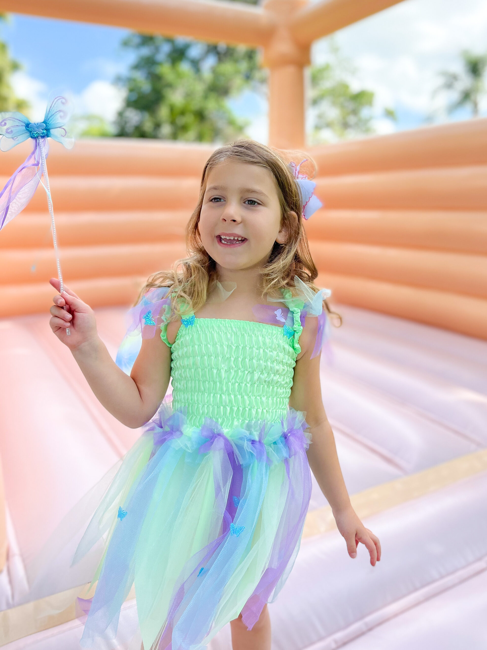 Emma in her fairy costume on the bounce house