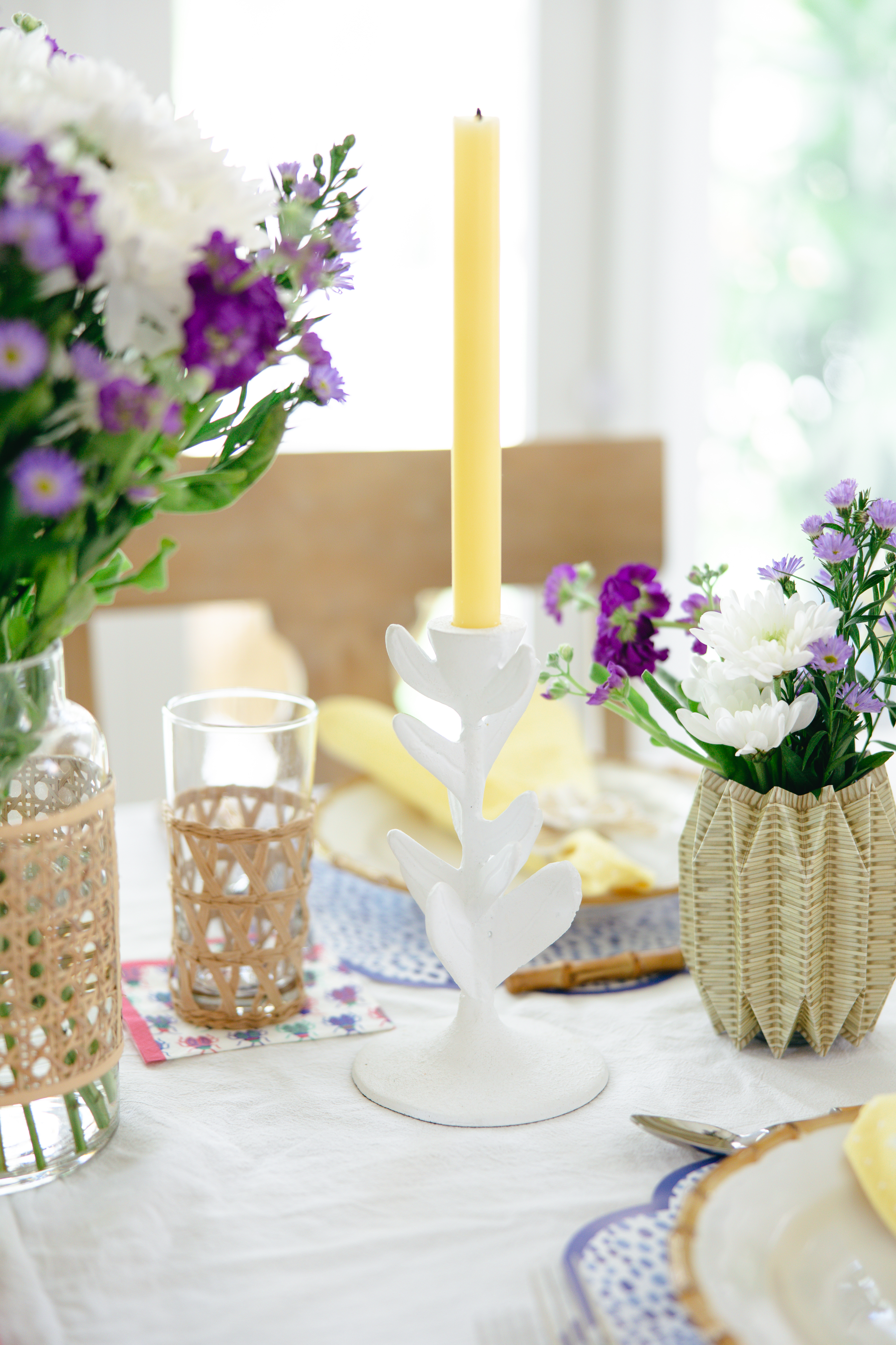 Close up of table and the white floral shaped candle stick and vases.
