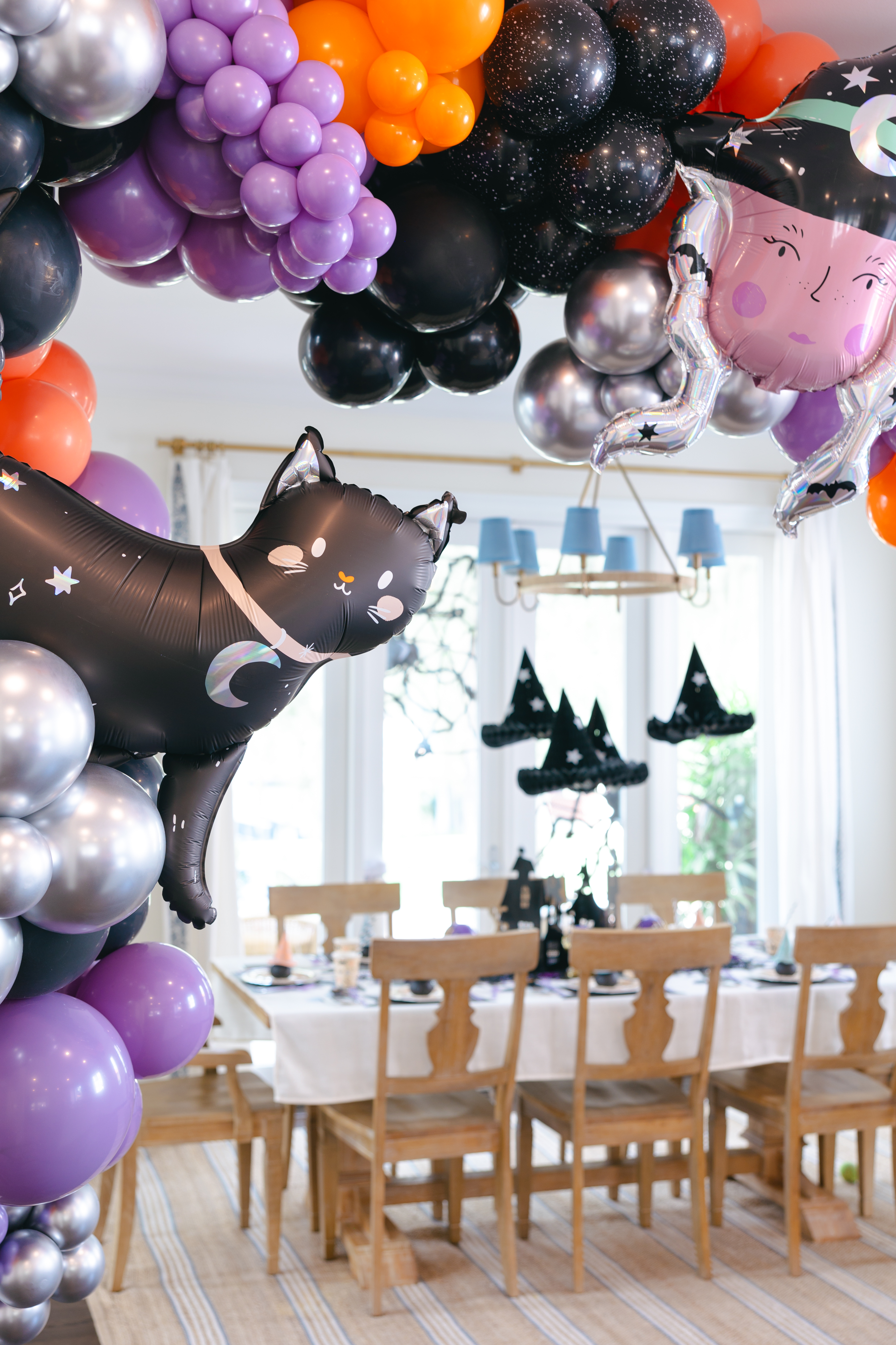 Balloon arch with purple, orange and black balloons and foil cat and witch balloon.