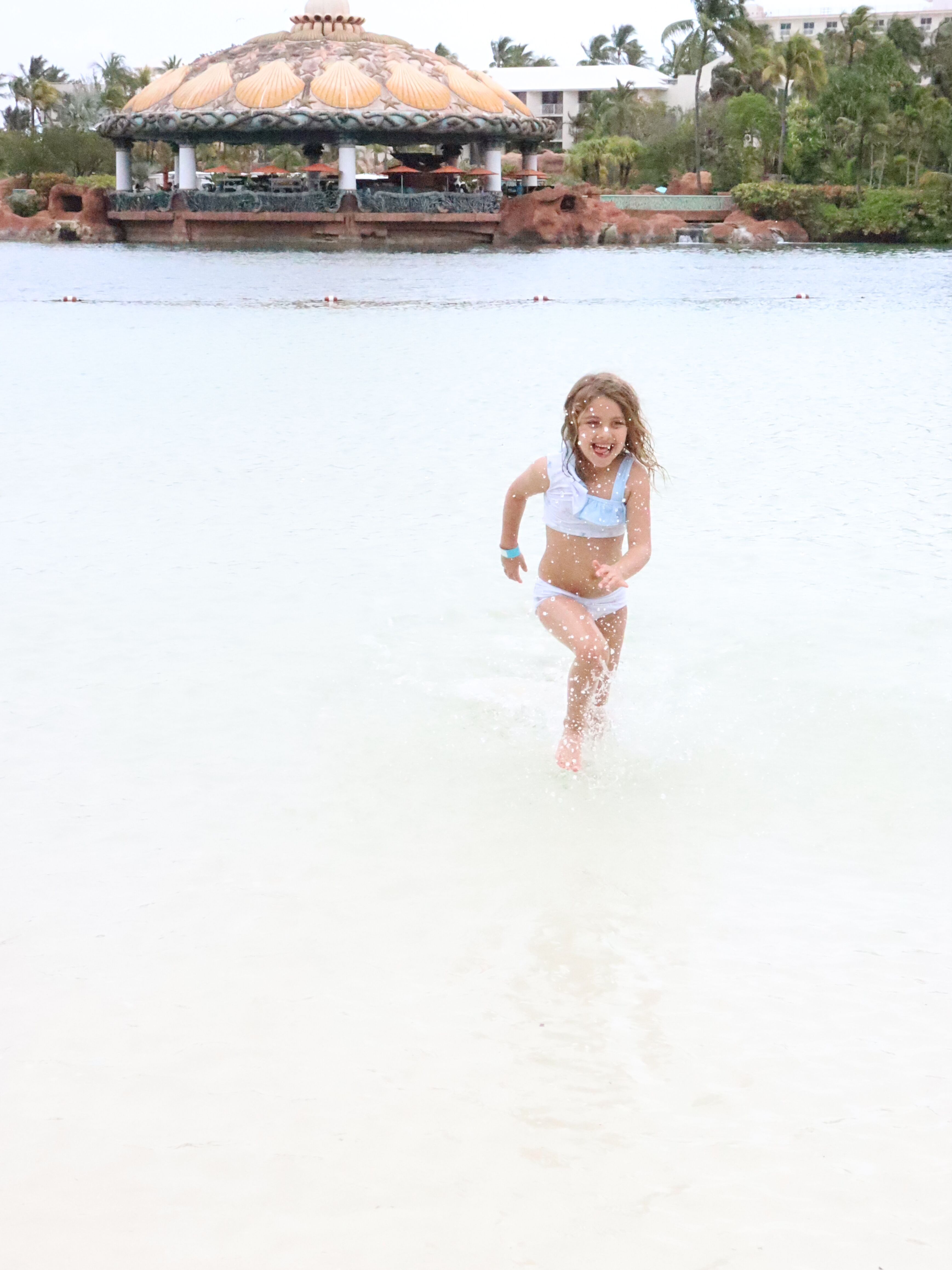 Katie running through the water at Atlantis' beach.